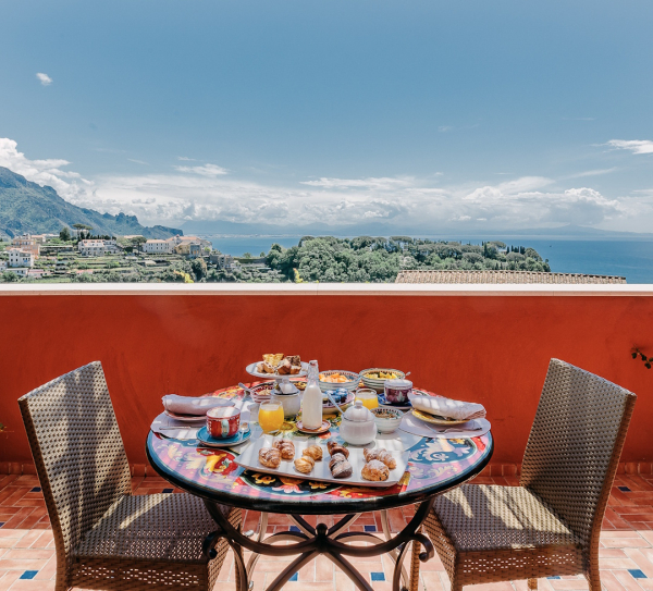 Breakfast table set with panoramic Amalfi Coast sea view in a luxury setting