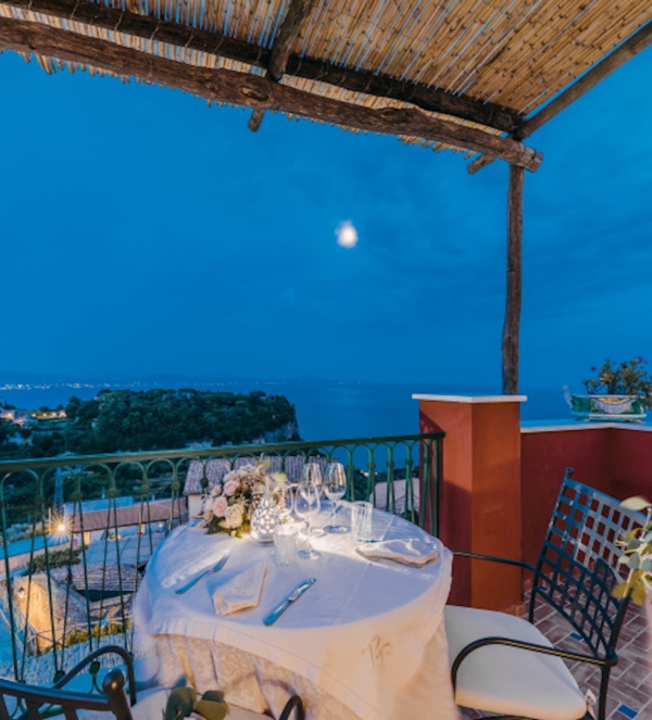 Cena romantica su terrazza privata con vista mare sulla Costiera Amalfitana al tramonto