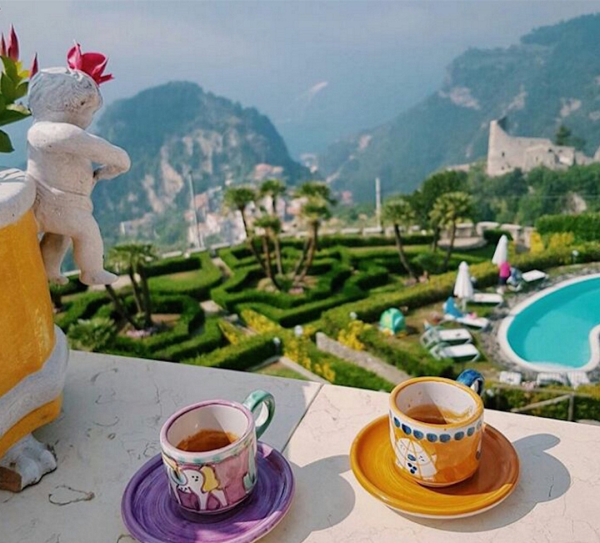 Colazione con vista sulla Costiera Amalfitana con tazze di caffè e panorama piscina per un’esperienza esclusiva