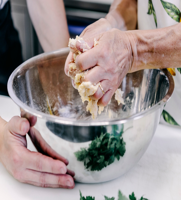 Hands kneading fresh pasta dough during a cooking class