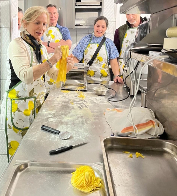 People making fresh pasta together during a cooking class in a professional kitchen