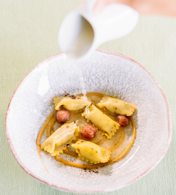 Chef completa l’impiattamento di un piatto gourmet durante un’esperienza Chef’s Table al Ristorante Gli Ulivi