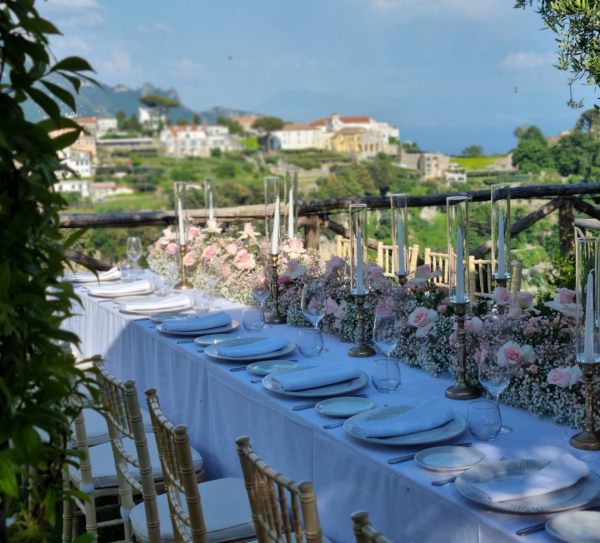 Elegant long table set for private dining with panoramic Amalfi Coast view at Palazzo Pascal