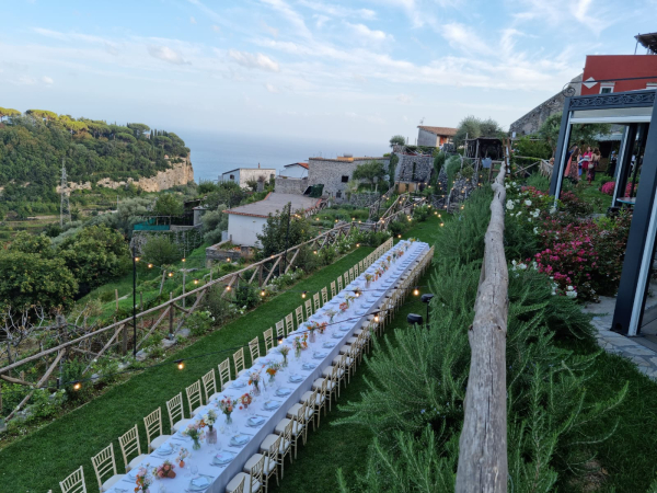 Tavolo imperiale allestito tra vigneti con vista sulla Costiera Amalfitana per una cena privata esclusiva